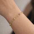 Pulsera trenzada con esferas Plata 925 enchape Oro 18K puesta en muñeca