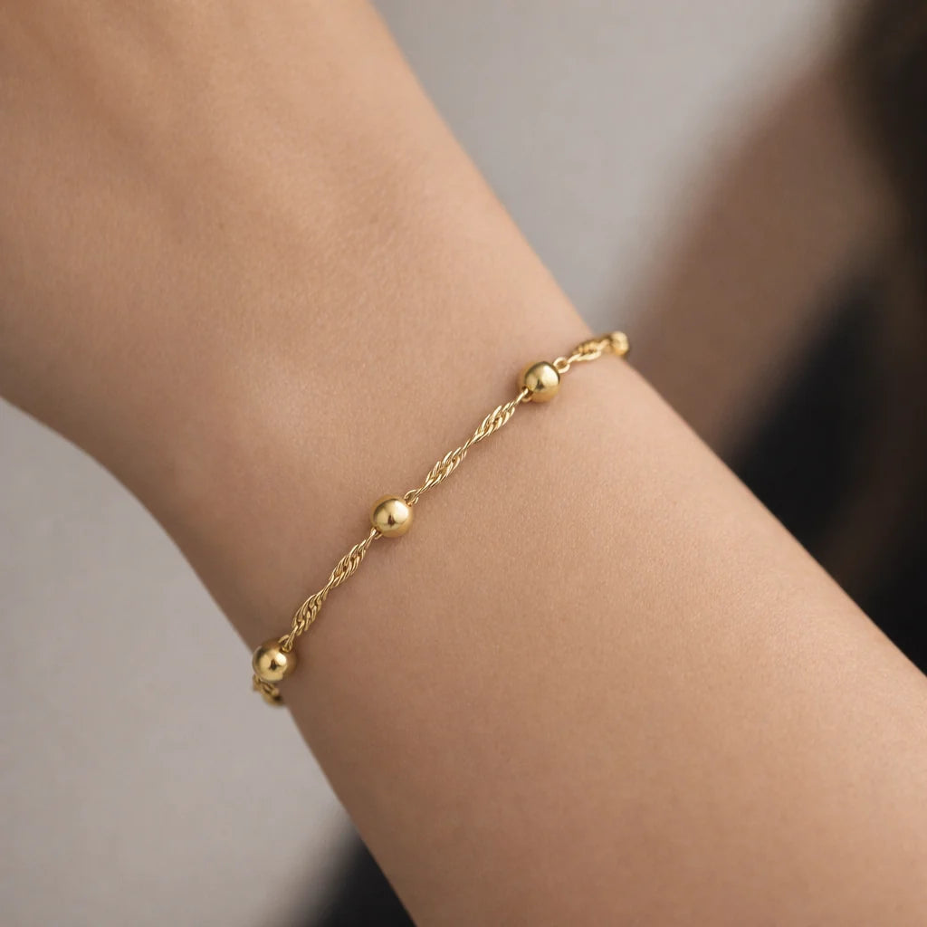 Pulsera trenzada con esferas Plata 925 enchape Oro 18K puesta en muñeca