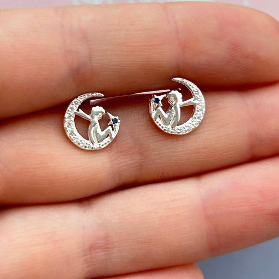 Aros en tono plateado con diseño de luna creciente y estrella